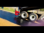 Amerispreader shown at work dropping stone chips Quachita County Arkansas roadway