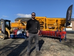 PavementGroup Operations Manager Devin Meyer shown standing in front of Olympus Pugmill, Amerispreader chip spreader and Ameripatcher pothole patcher asphalt recycler