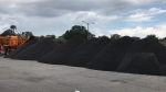 pugmill system by Olympus shown producing multiple piles of cold mix asphalt 