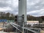 Pugmill System designed for liquid waste solidification by PavementGroup.com shown with sludge bin, incline screw, pugmill and silo, easily transportable shown with axles